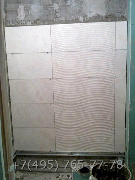 Облицовка плиткой стены с узором возле туалета
