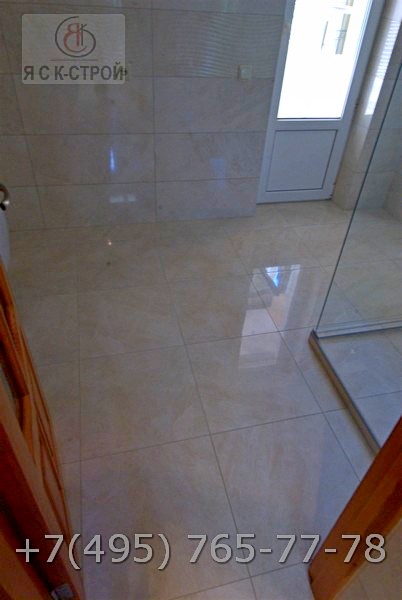 Выложена керамогранит ной плиткой на полу в ванной комнате